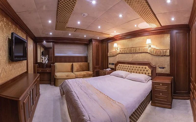 a large bedroom with a bed and a couch aboard IRAMA Yacht for Sale