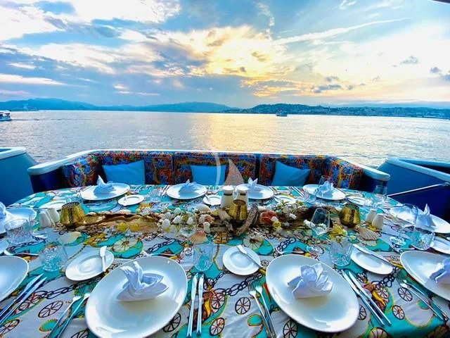 a table with plates and food on it aboard IRAMA Yacht for Sale