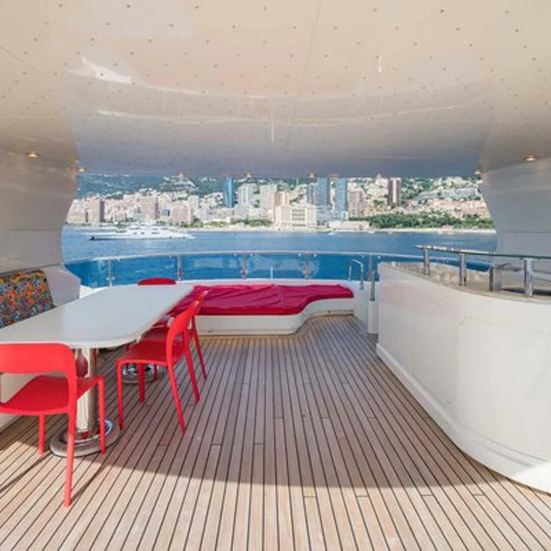 a room with a table chairs and a view of a city aboard IRAMA Yacht for Sale