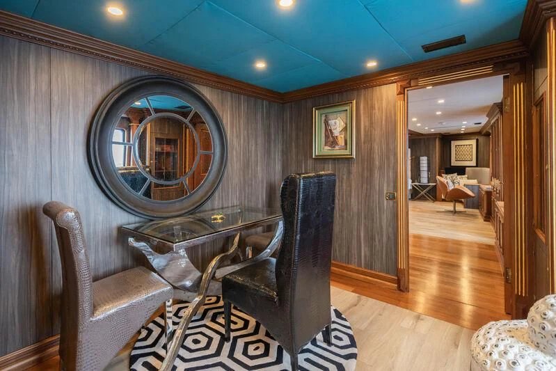 a room with a mirror and couches aboard IRAMA Yacht for Sale