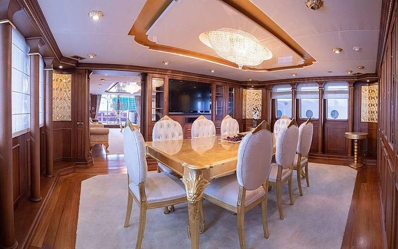 a large dining table in a room aboard IRAMA Yacht for Sale