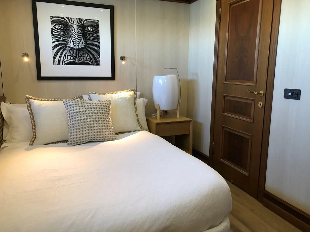 a bed with a white comforter and pillows aboard IRAMA Yacht for Sale