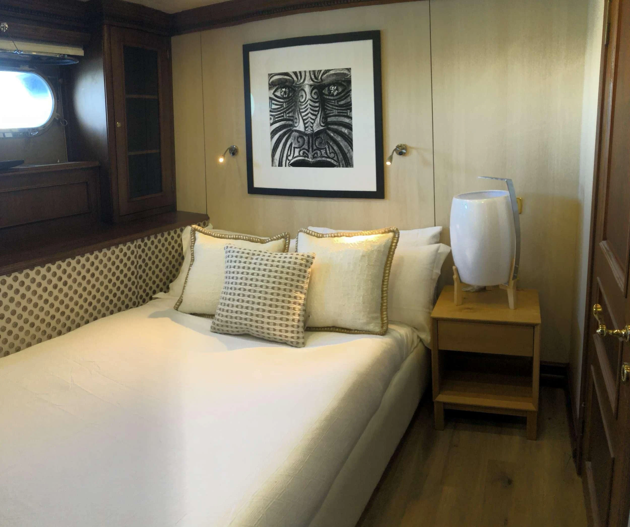 a bed with a white sheet and pillows aboard IRAMA Yacht for Sale