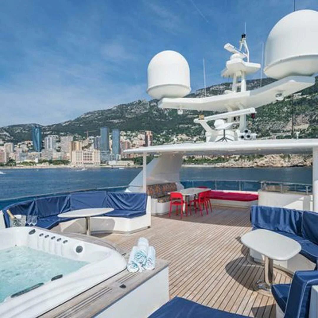 a deck with a deck and a view of a city and water aboard IRAMA Yacht for Sale