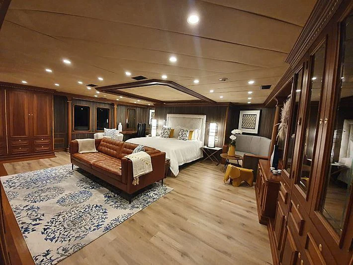 a room with a bed and a couch aboard IRAMA Yacht for Sale