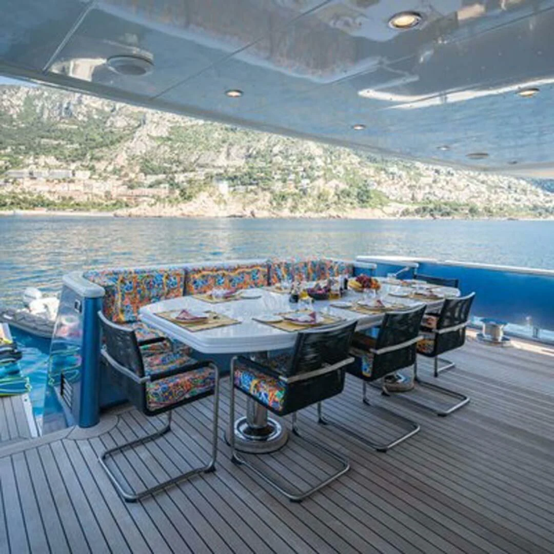 a table and chairs on a deck aboard IRAMA Yacht for Sale