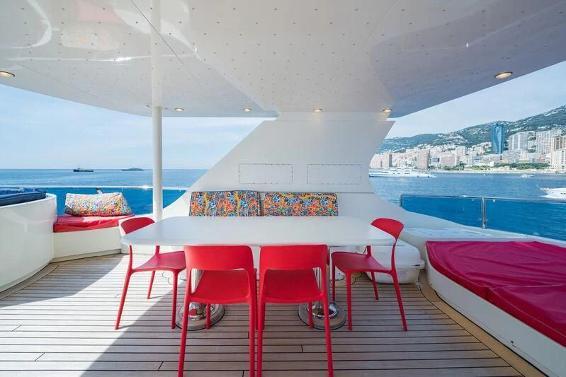 a table and chairs on a patio aboard IRAMA Yacht for Sale