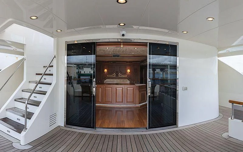 a room with a glass door and a staircase aboard IRAMA Yacht for Sale