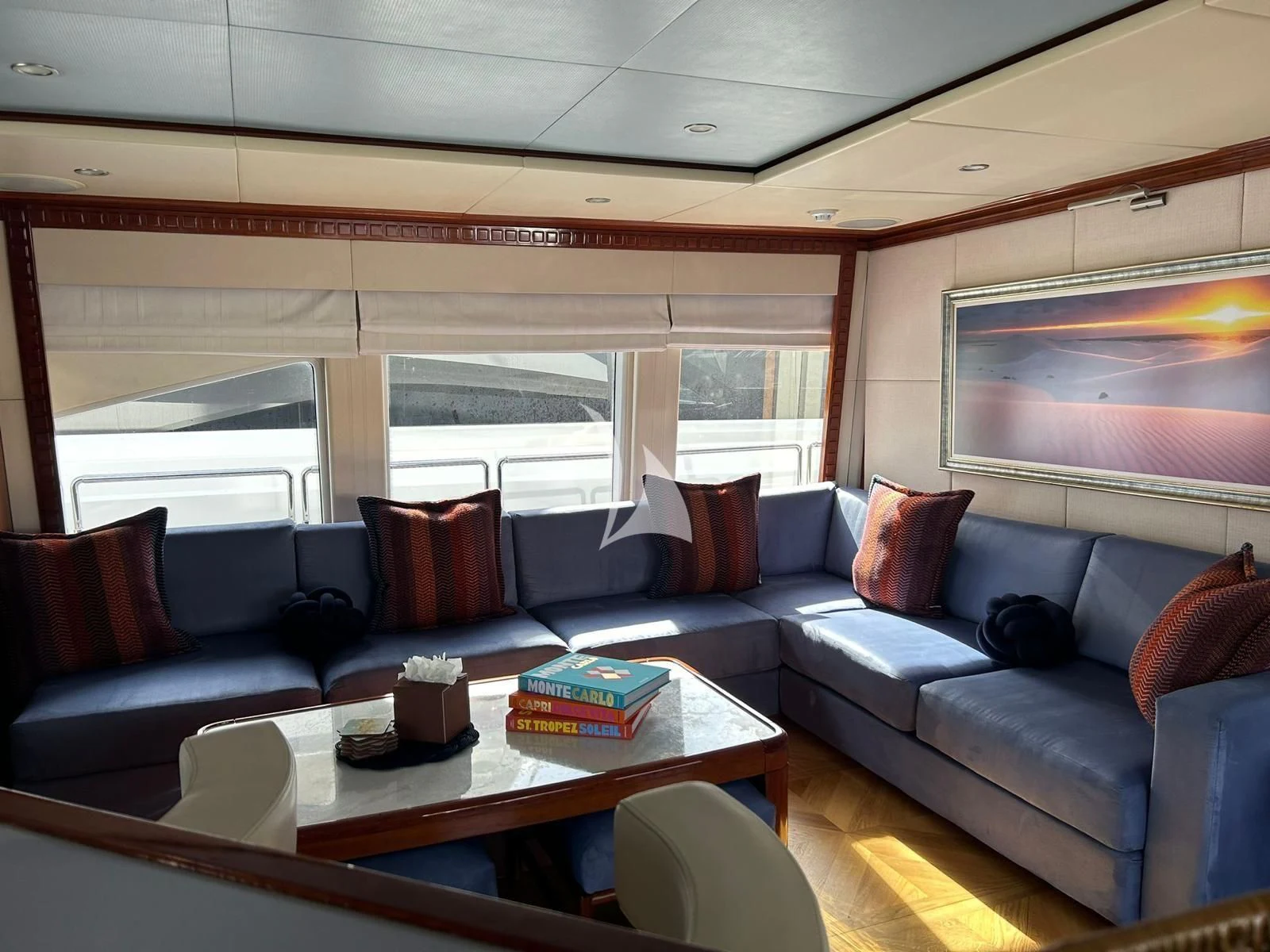 a living room with a blue couch and a large window aboard GRAND CRU Yacht for Sale