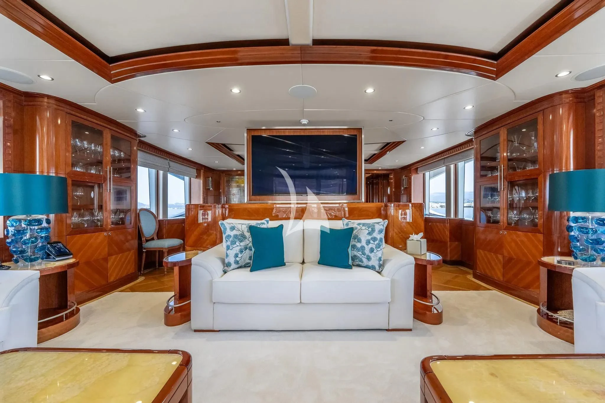 a large living room with a white couch and a wood cabinet aboard GRAND CRU Yacht for Sale