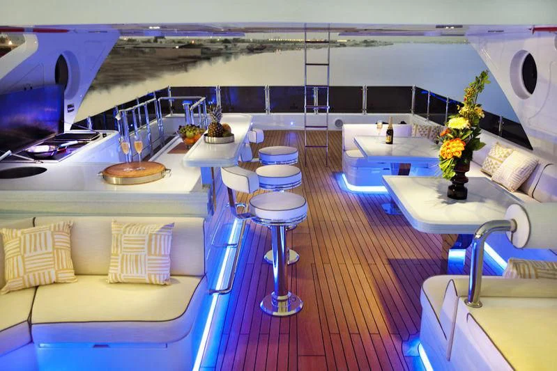 a room with a boat and a table with chairs aboard GRAND CRU Yacht for Sale