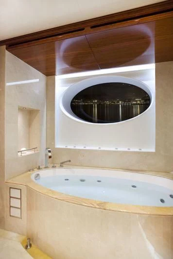 a bathtub with a round window aboard GRAND CRU Yacht for Sale