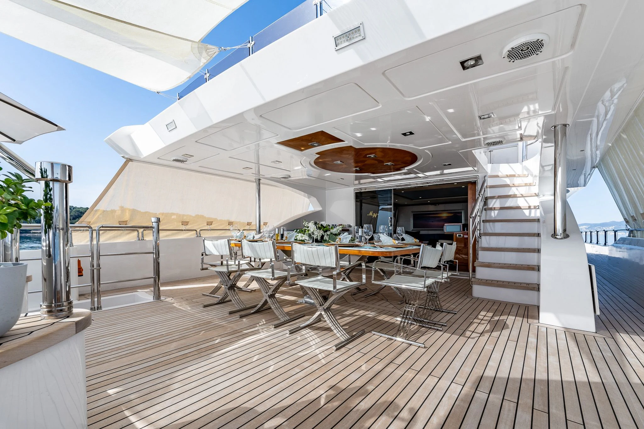 a room with a staircase and tables aboard GRAND CRU Yacht for Sale