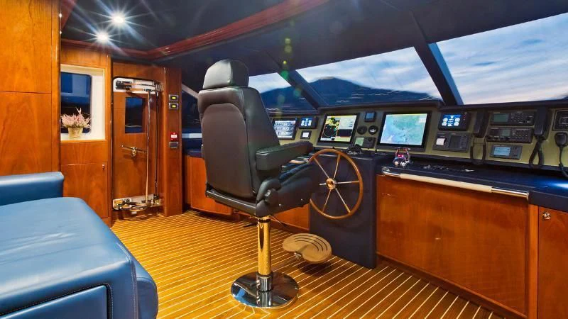 a room with a large chair and a table with a large wheel aboard GRAND CRU Yacht for Sale