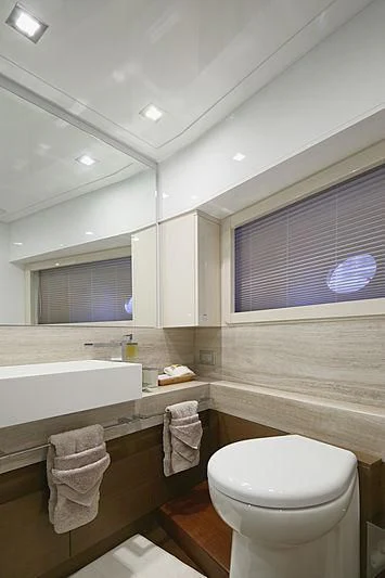 a bathroom with a toilet and a sink aboard TOP SHELF Yacht for Sale