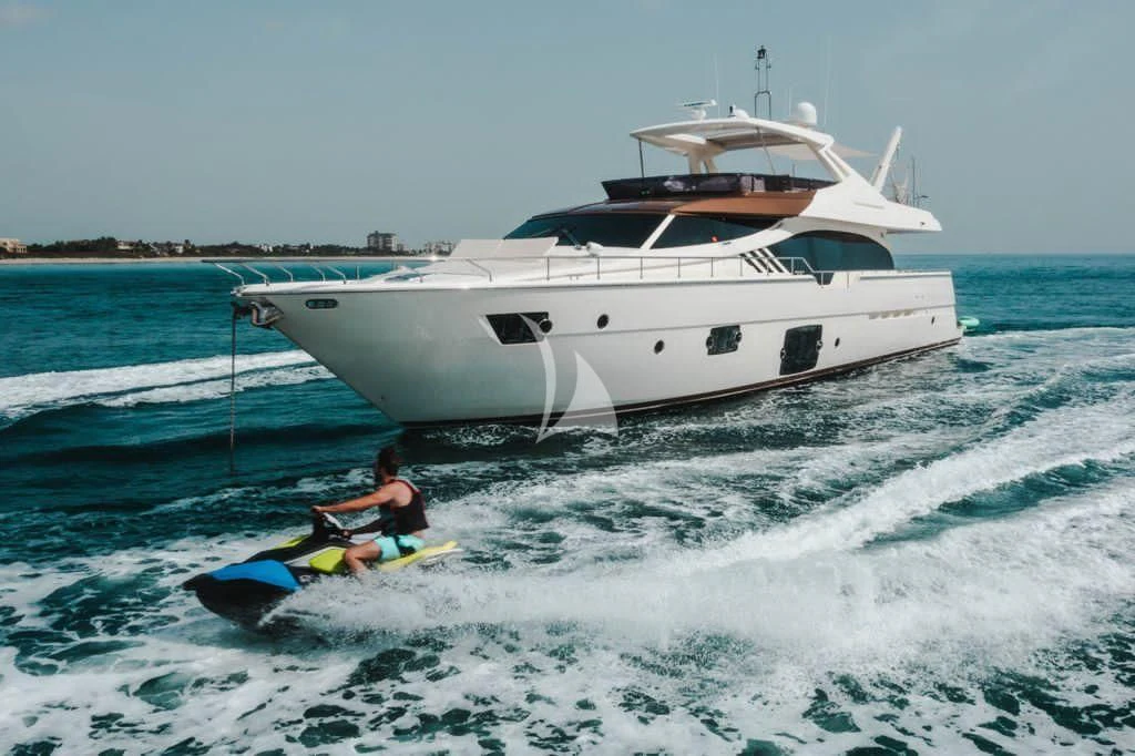 a person on a jet ski in the water next to a boat aboard TOP SHELF Yacht for Sale