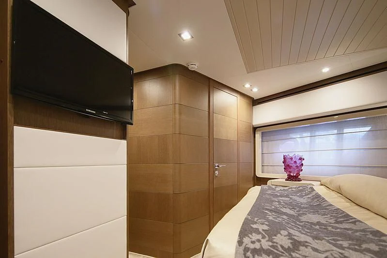 a bedroom with a bed and a tv aboard TOP SHELF Yacht for Sale