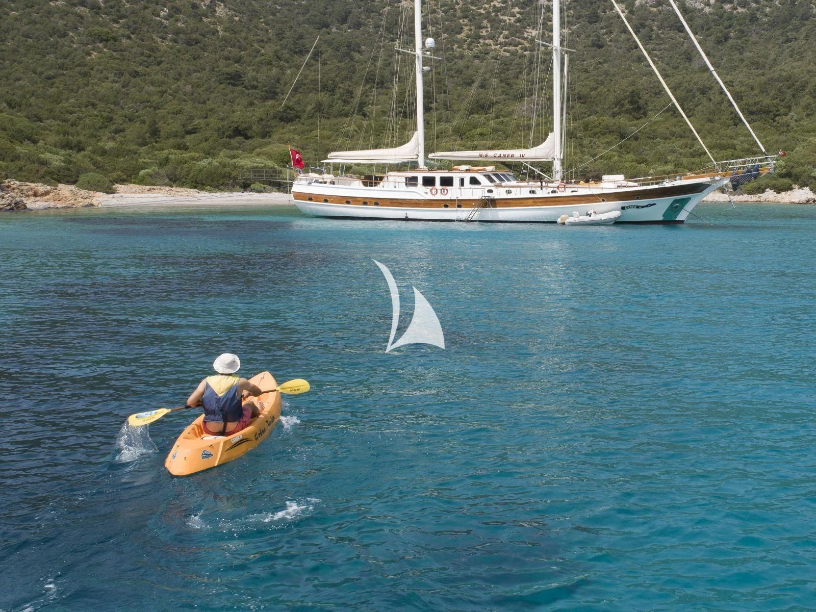 a boat and a person in a kayak in the water aboard CANER IV Yacht for Sale