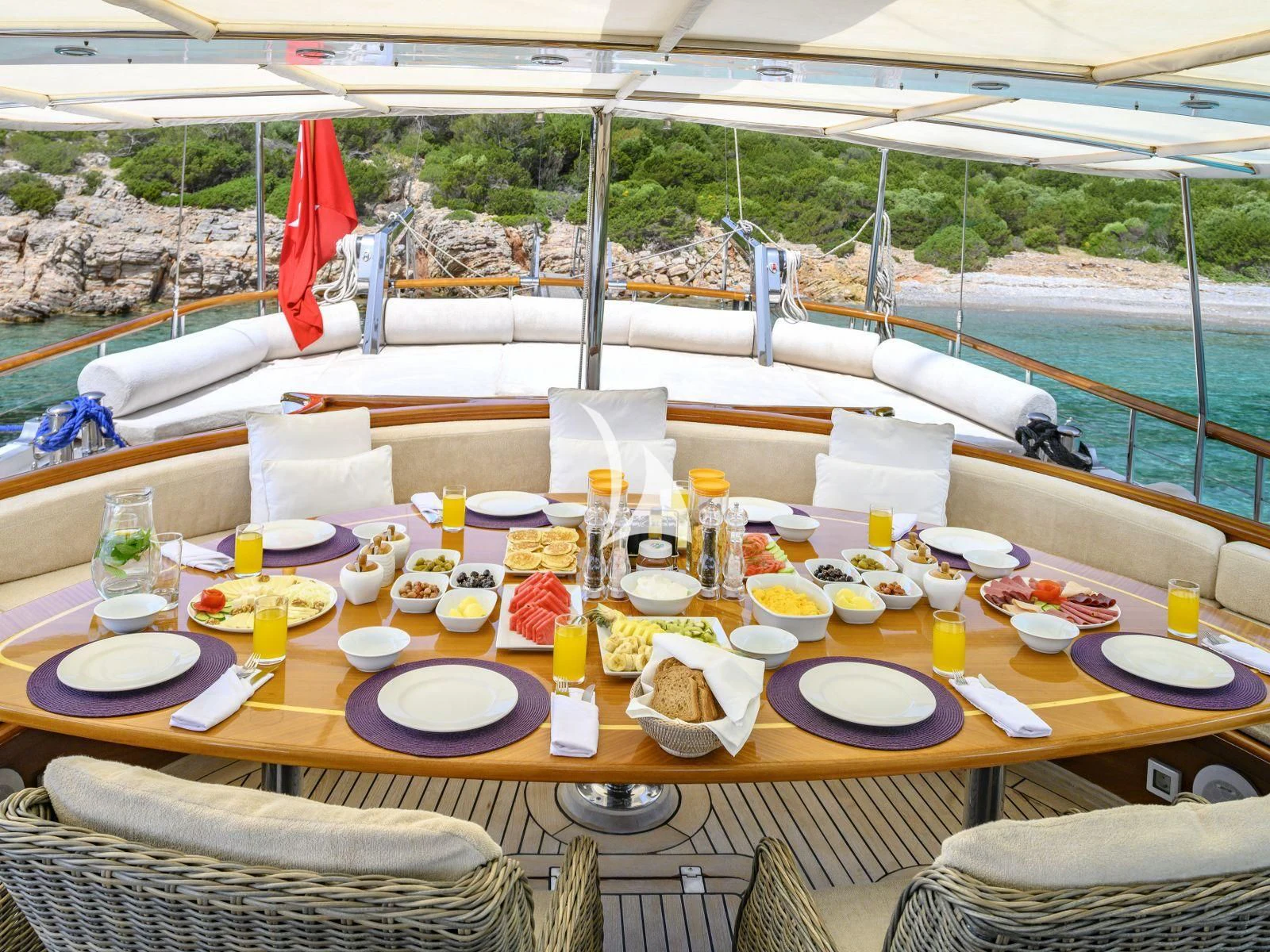 a table with plates and food on it aboard CANER IV Yacht for Sale