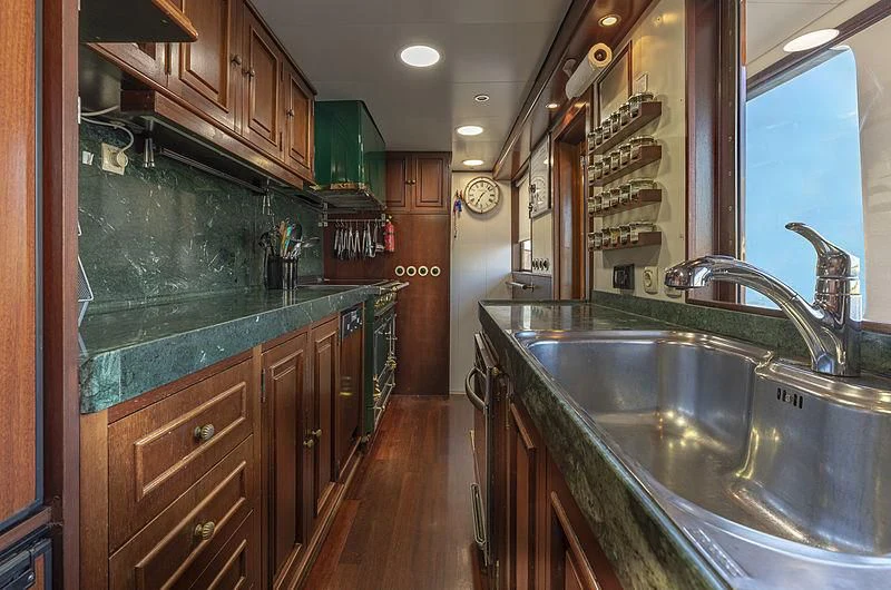 a kitchen with wooden cabinets aboard MONTREVEL Yacht for Sale