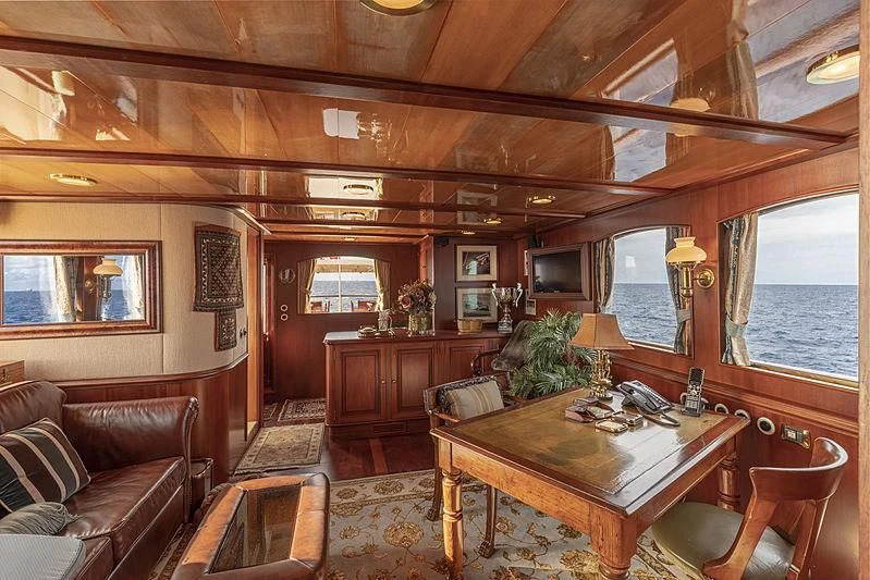 a living room with a table and couches aboard MONTREVEL Yacht for Sale