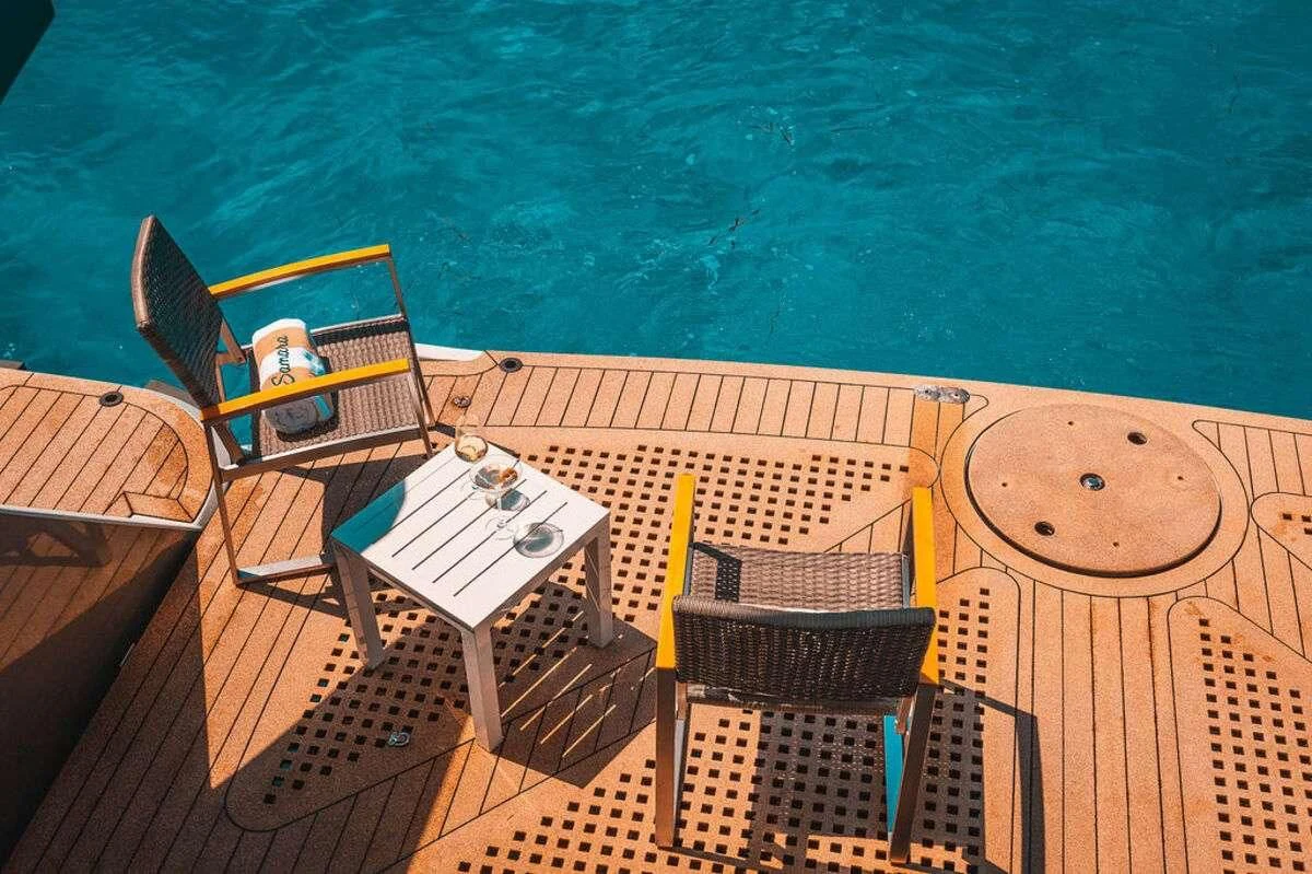 a deck with chairs and a table on it aboard SAMARA Yacht for Charter