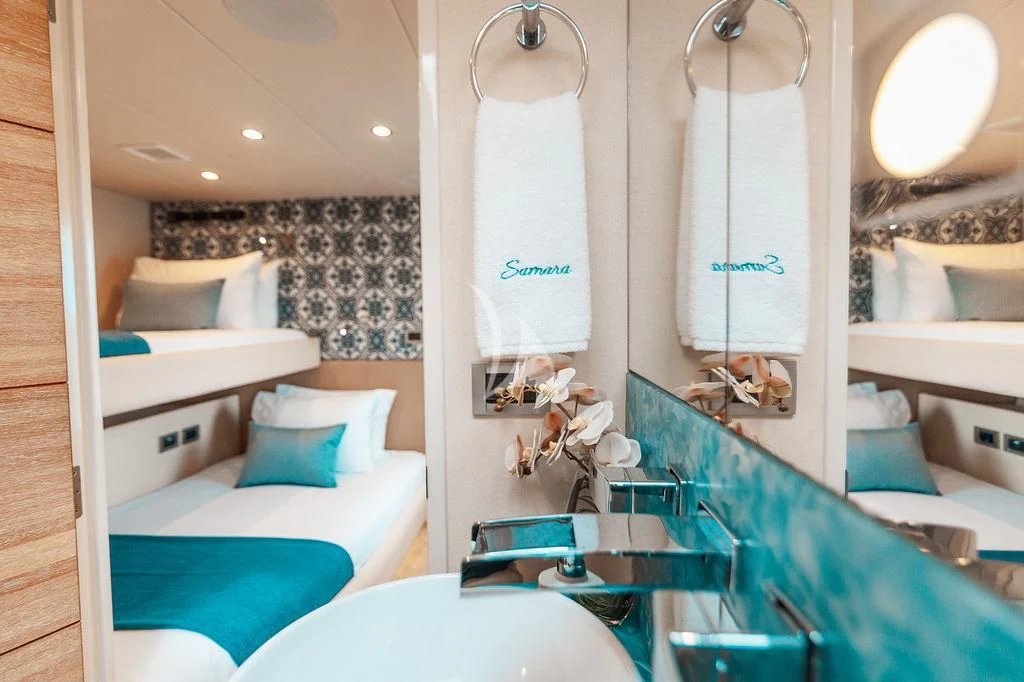 a room with a couple of beds and a sink aboard SAMARA Yacht for Charter