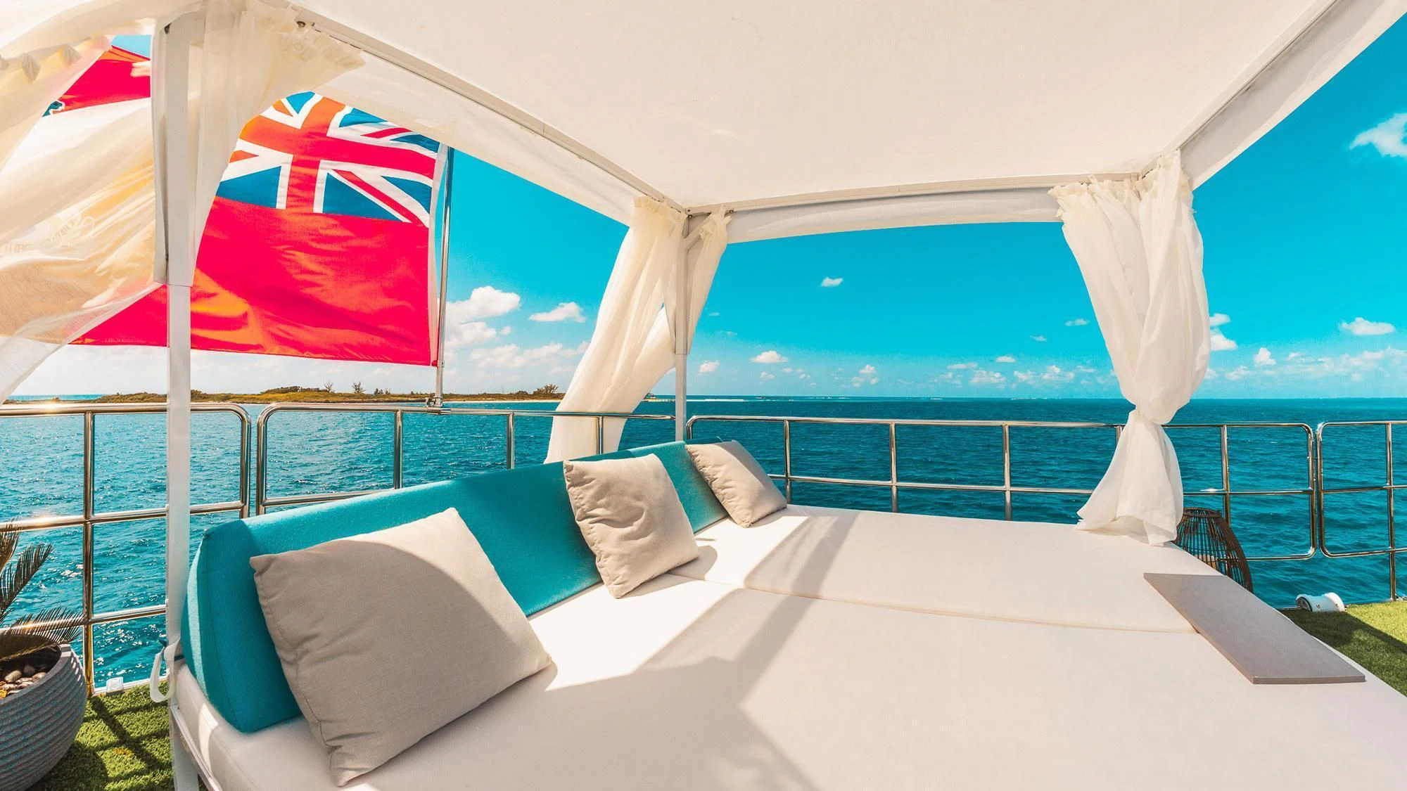 a large white bed with a flag on it aboard SAMARA Yacht for Charter