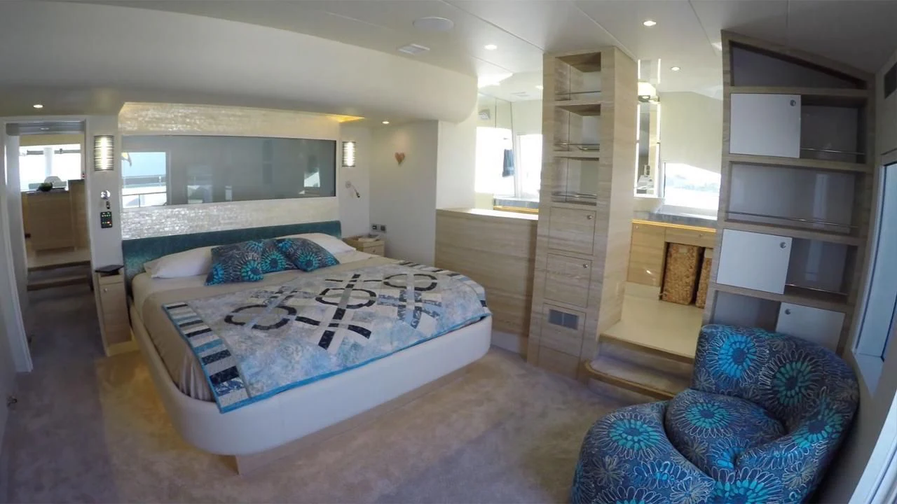 a bedroom with a bed and a chair aboard SAMARA Yacht for Charter