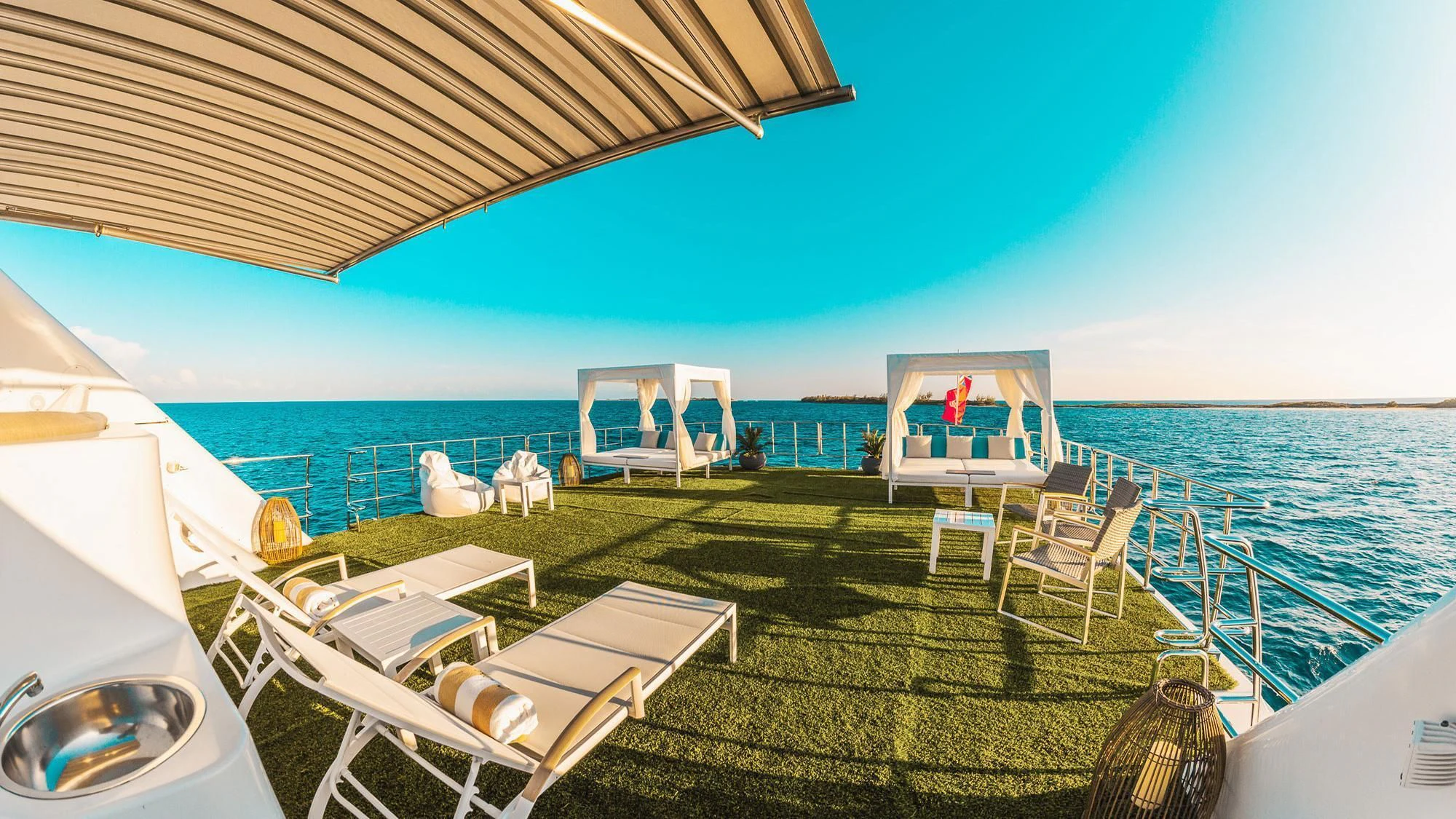 a deck with chairs and a table on it by the water aboard SAMARA Yacht for Charter