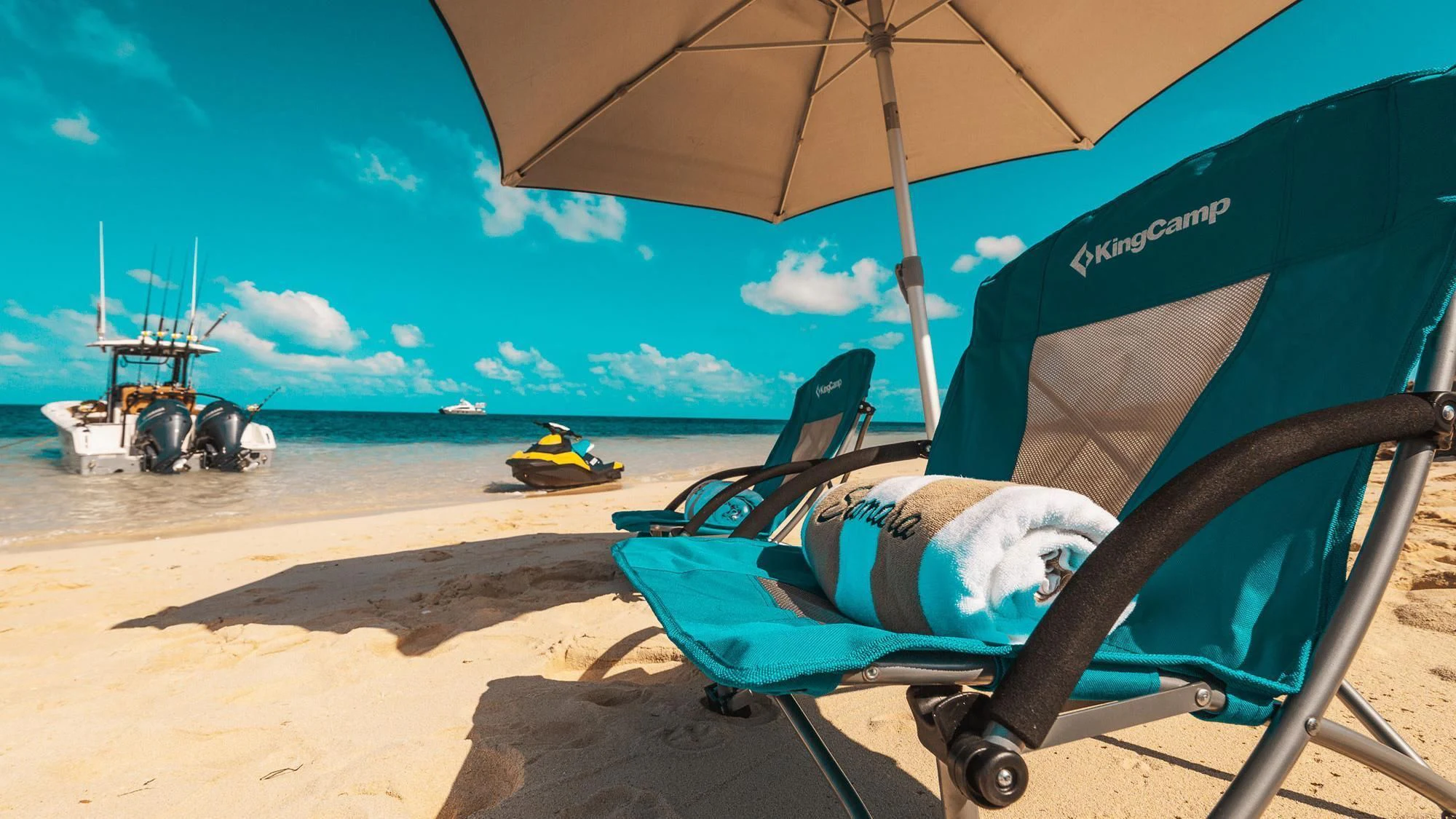 a person lying in a hammock under an umbrella on a beach aboard SAMARA Yacht for Charter