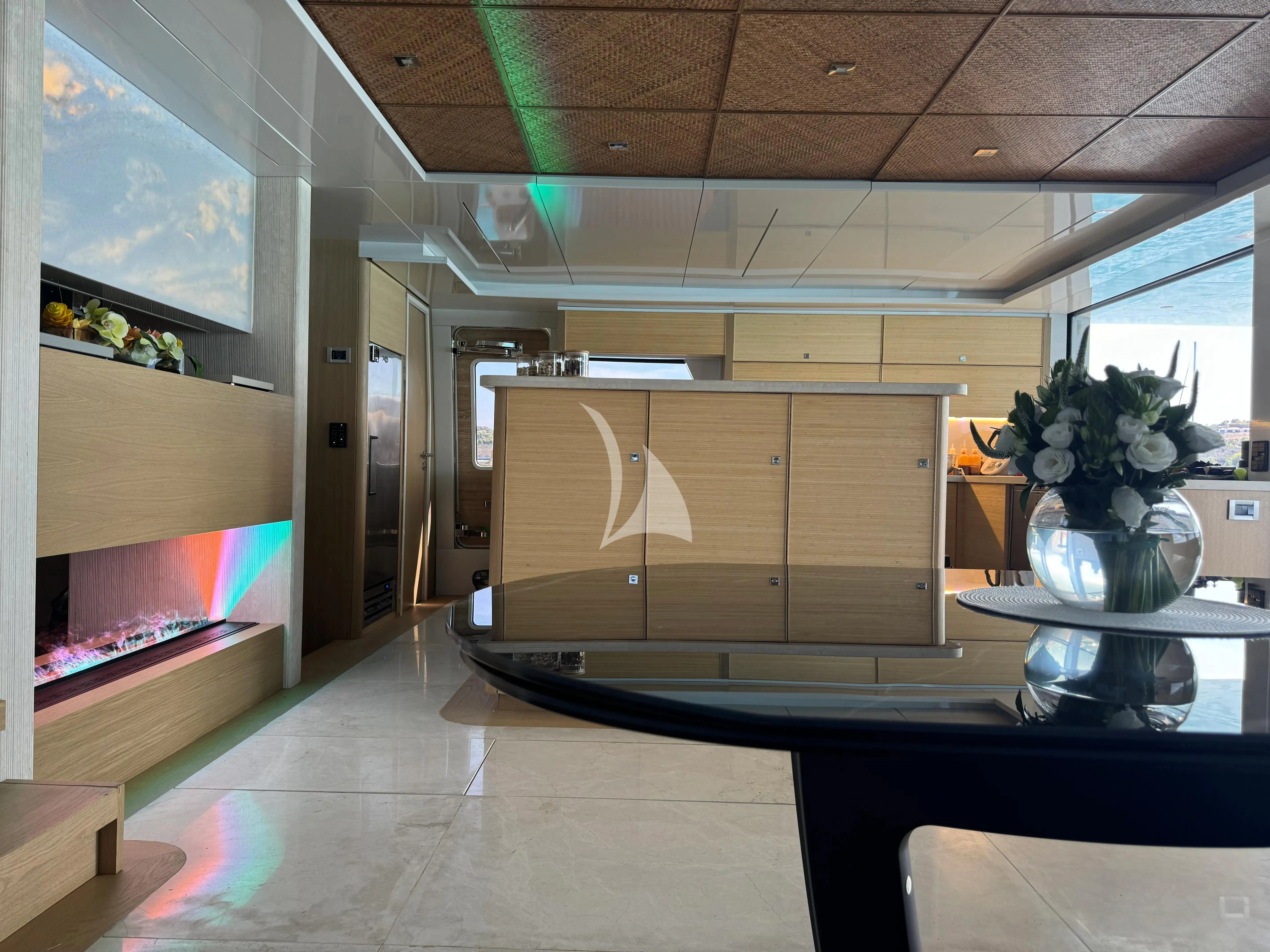 a room with a glass wall and a desk with a chair and a window with a plant on aboard SAMARA Yacht for Charter