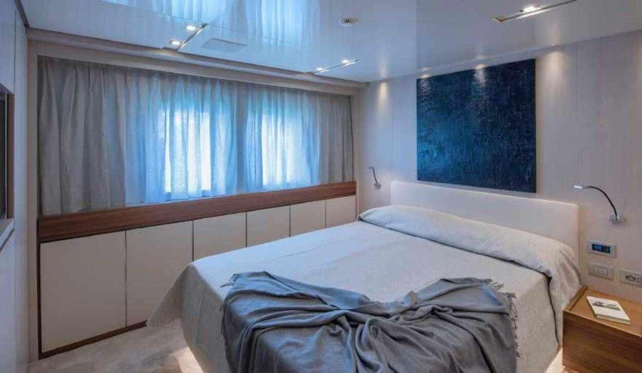 a room with a bed and a window aboard OCTAVE Yacht for Sale