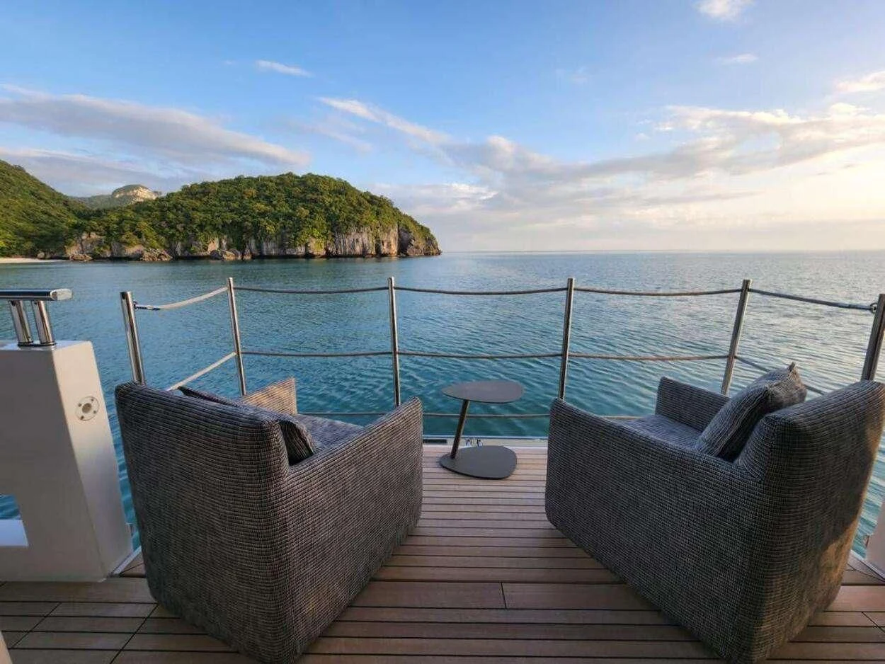 a deck with chairs and a body of water in the background aboard OCTAVE Yacht for Sale