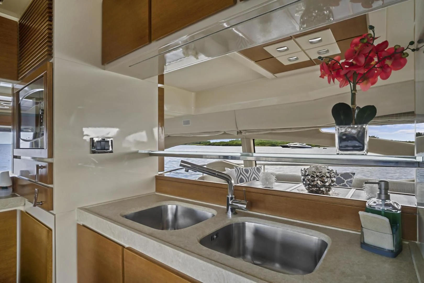 a kitchen with a sink and a shelf with flowers aboard WICKED Yacht for Sale