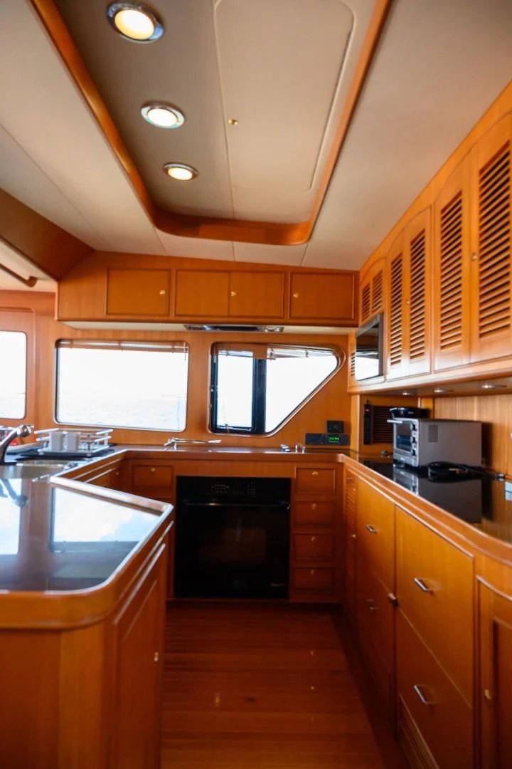 a kitchen with wooden cabinets aboard VK Yacht for Sale