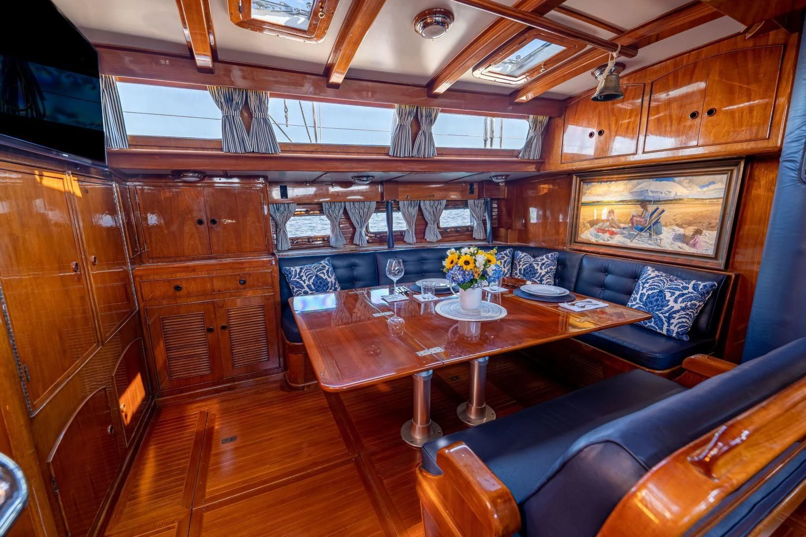 a room with wooden cabinets and a table and chairs aboard HERMIE LOUISE Yacht for Sale