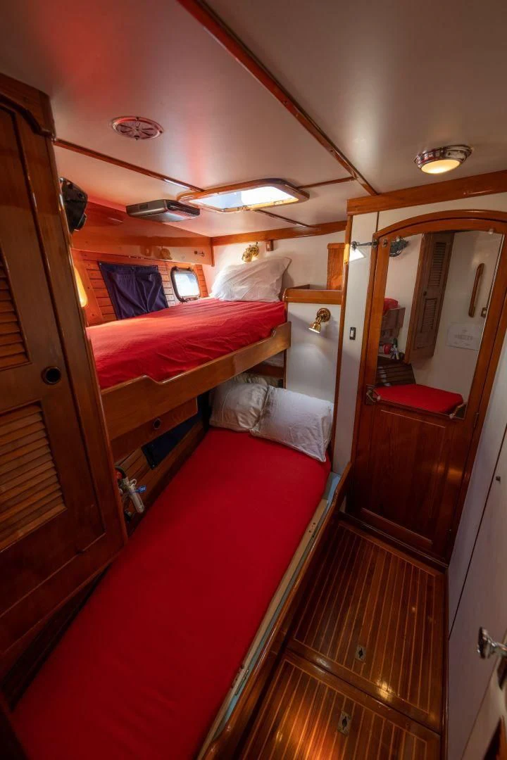 a room with a bed and a mirror aboard HERMIE LOUISE Yacht for Sale