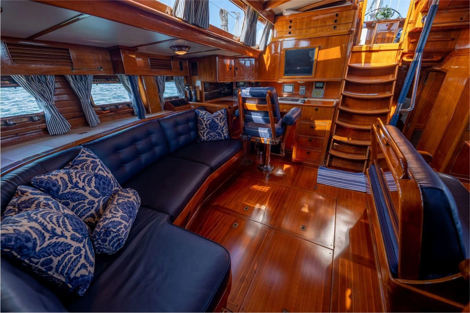 a room with a wood floor and couches aboard HERMIE LOUISE Yacht for Sale