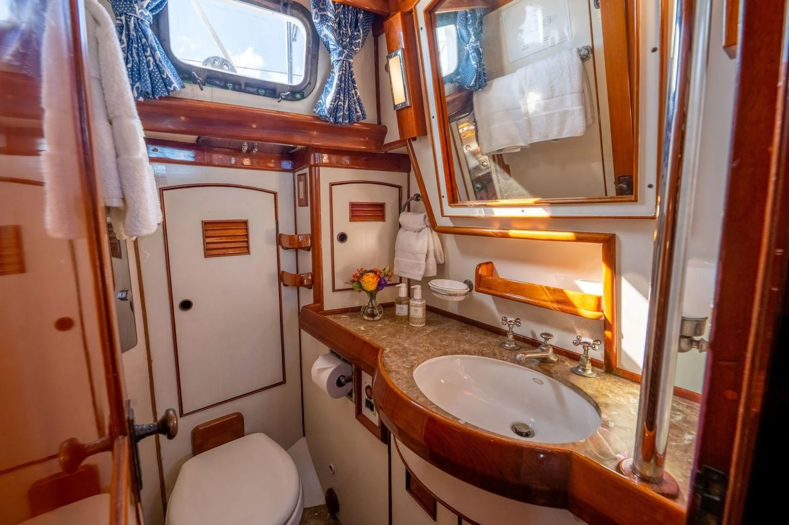 a bathroom with a sink toilet and a mirror aboard HERMIE LOUISE Yacht for Sale