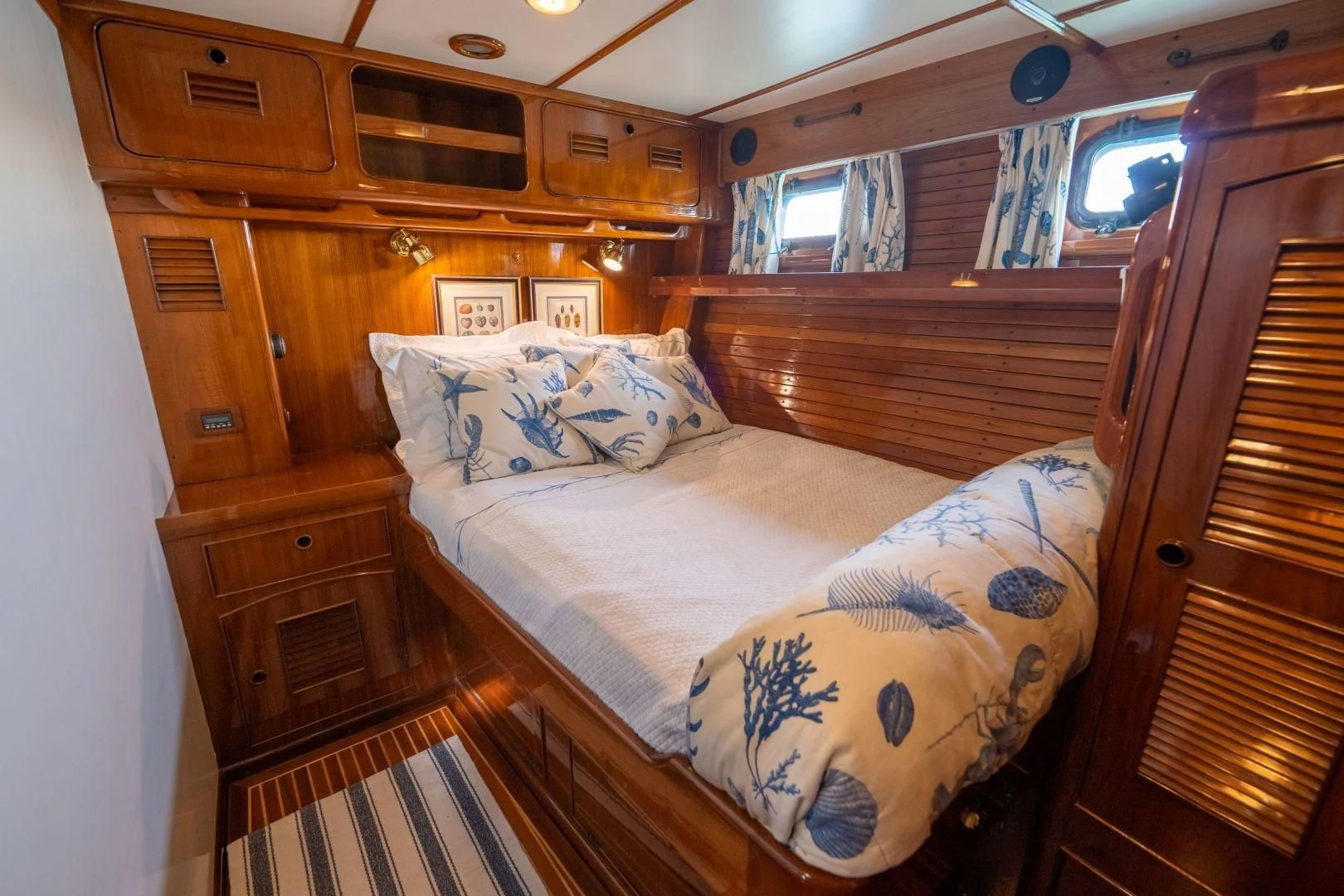 a bedroom with a bed and a wood cabinet aboard HERMIE LOUISE Yacht for Sale