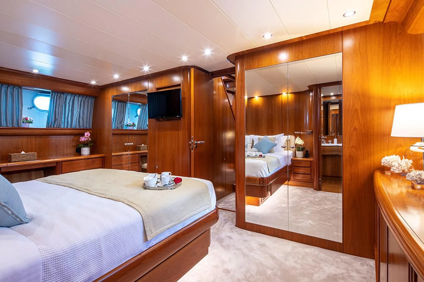 a bedroom with a bed and a mirror aboard VYNO Yacht for Sale