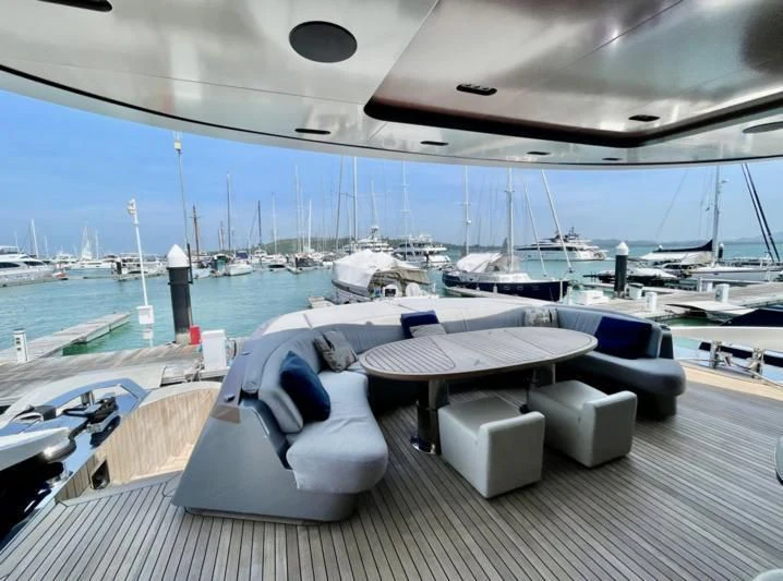a deck with a table and chairs on it by a body of water aboard LA VIE Yacht for Sale