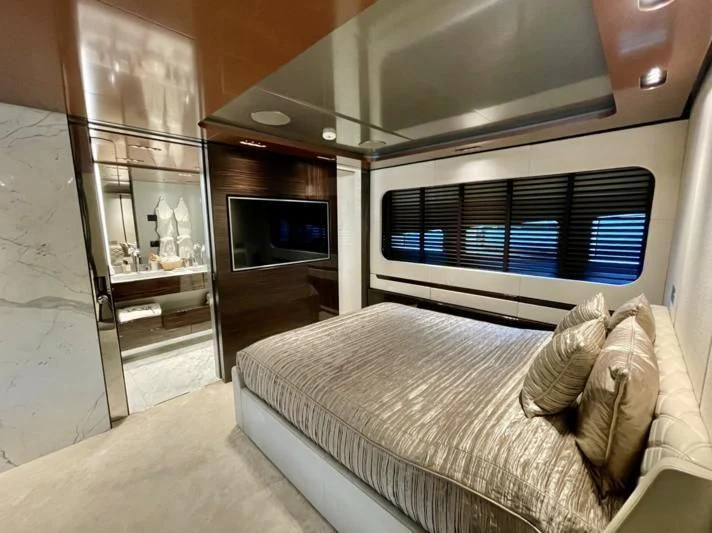 a bedroom with a bed and a tv aboard LA VIE Yacht for Sale
