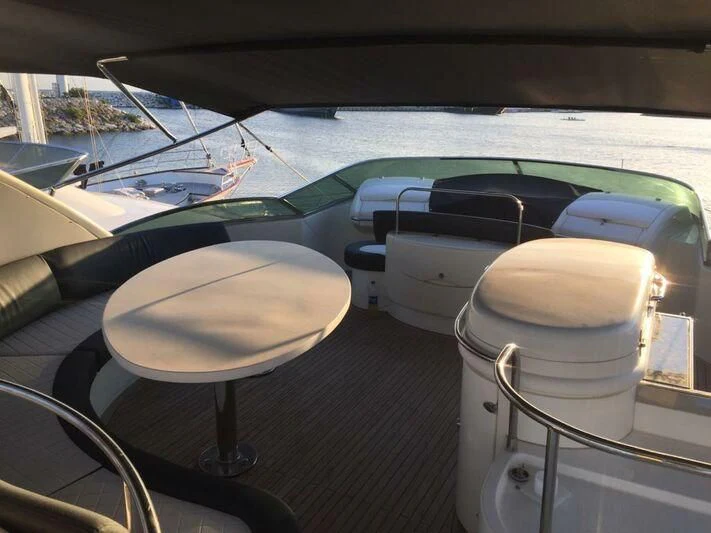 a table and chairs on a deck aboard AEGINA Yacht for Sale