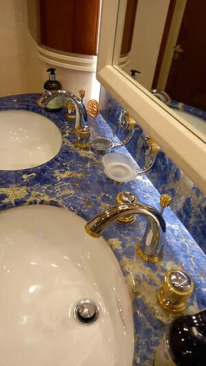a bathroom sink with a blue faucet aboard AEGINA Yacht for Sale