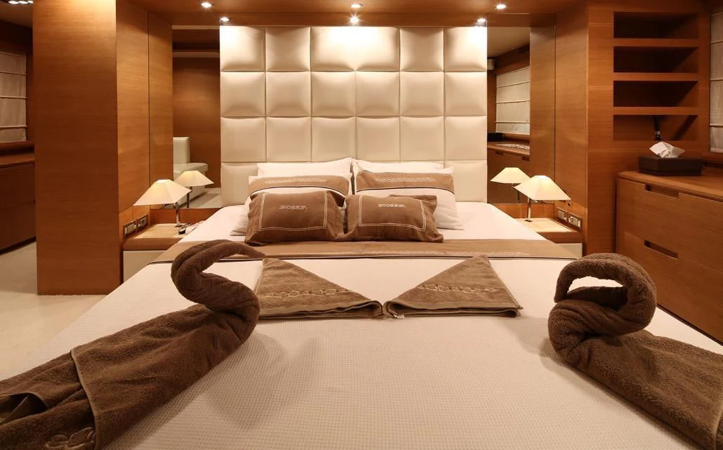 a large bed with a white comforter and pillows aboard YVONNE Yacht for Sale