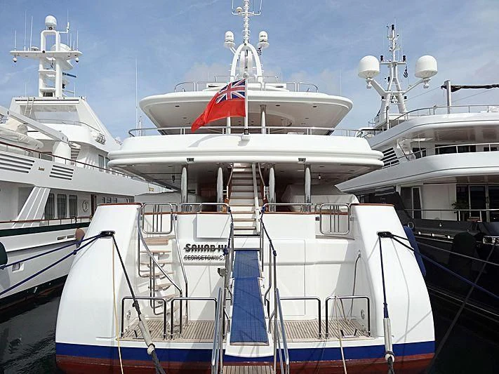 a large white boat with a red stripe on it aboard SAHAB IV Yacht for Sale