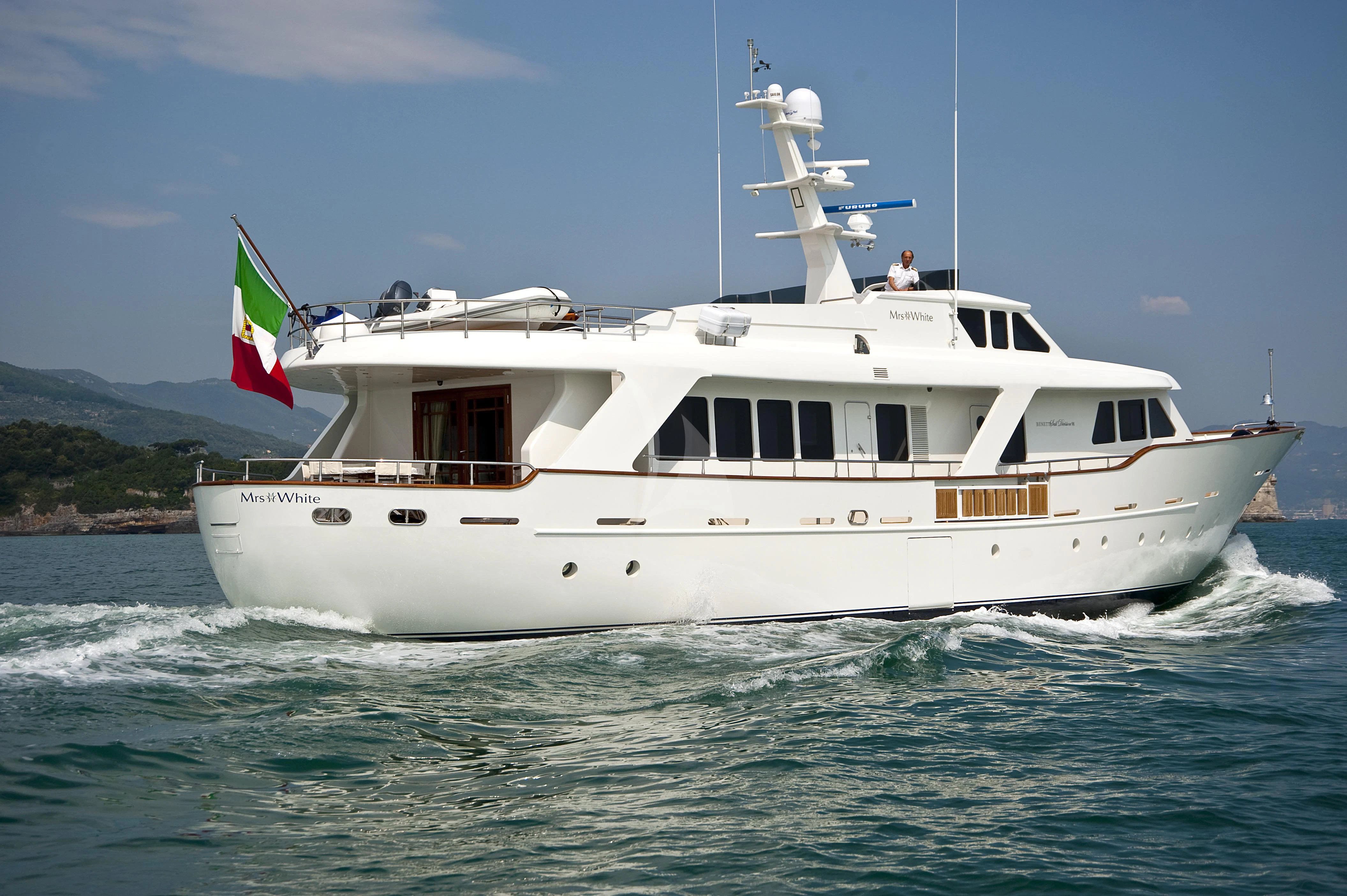 a large white boat with a flag on it aboard MRS. WHITE Yacht for Sale