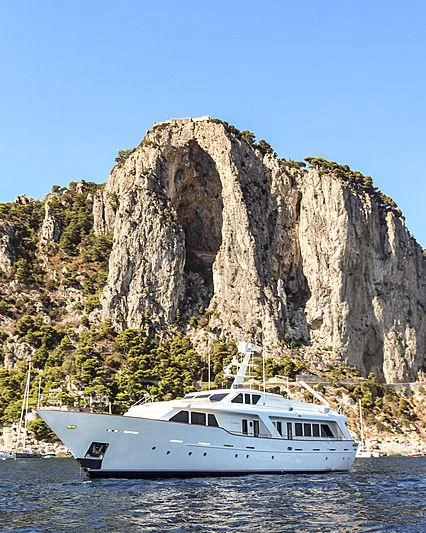a boat in the water by a cliff aboard MRS. WHITE Yacht for Sale